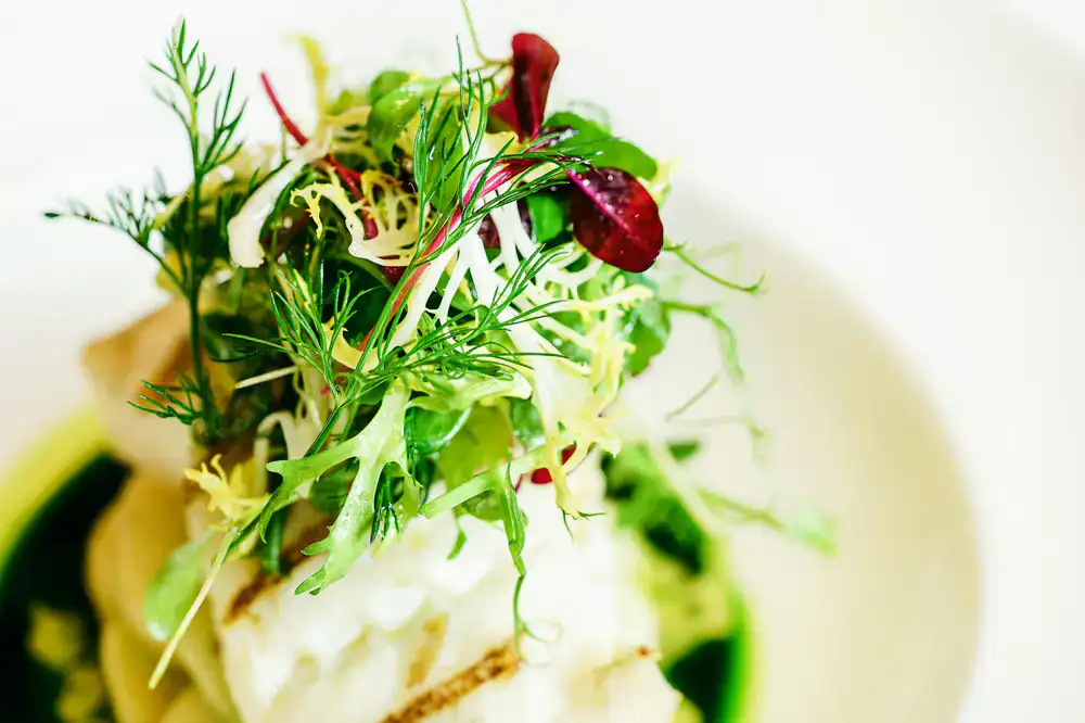 Ein Gericht wird in einem Restaurant mit Microgreens verfeinert